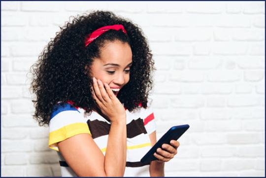 woman looking at cell phone screen with surprised look on her face