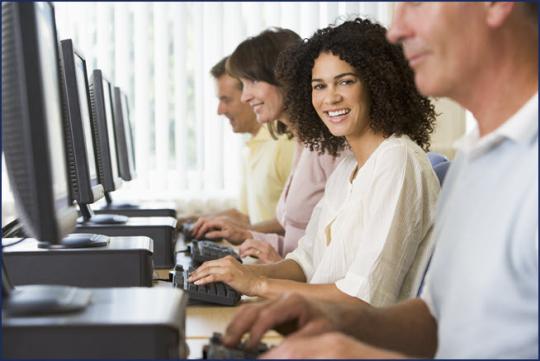 woman sitting at desk smiling toward camera