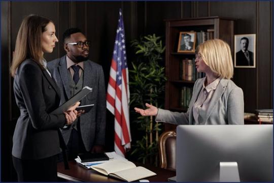 Three professionals standing in an office speaking to each other
