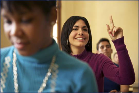 woman raising her hand in a classroom